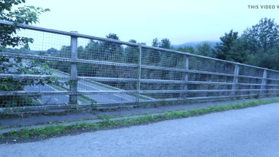 crossdressed outdoors on a motorway bridge