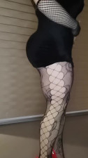 Sexy crossdresser in highheels black minidress and stockings girl facemask