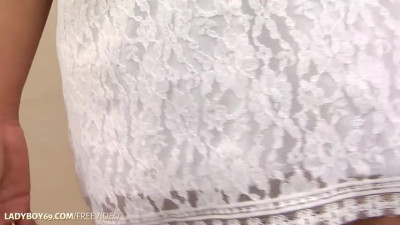 Brunette ladyboy in white dress strips her black panties and jerks off