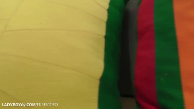 Brunette ladyboy in black and orange dress strokes her small cock